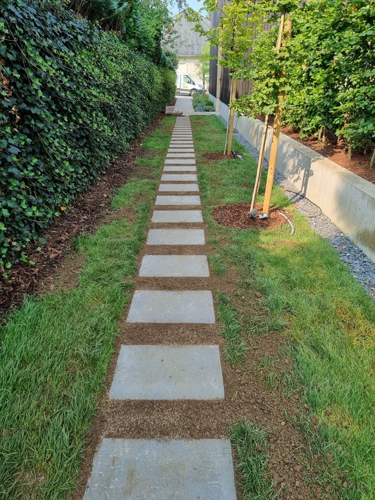 Allée de pas japonais en dalles de pierre serties dans une pelouse engazonnée, réalisation Green Space